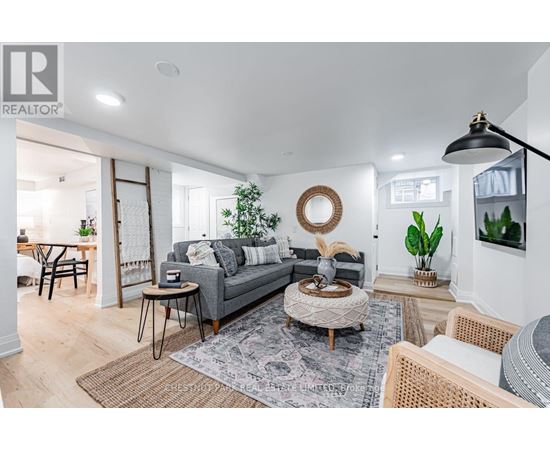 A living room with a grey sofa, a round coffee table, and a rug with a pattern.