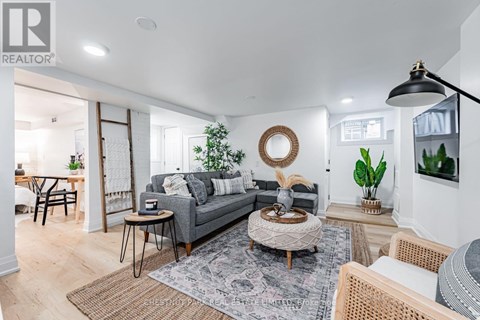 A living room with a grey sofa, a round coffee table, and a rug with a pattern.