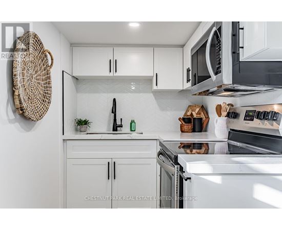 A modern kitchen with white cabinets and stainless steel appliances.