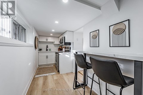 A kitchen with white cabinets and a white counter top.