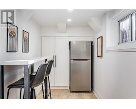 A kitchen with a white table and black chairs.