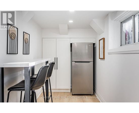 A kitchen with a white table and black chairs.