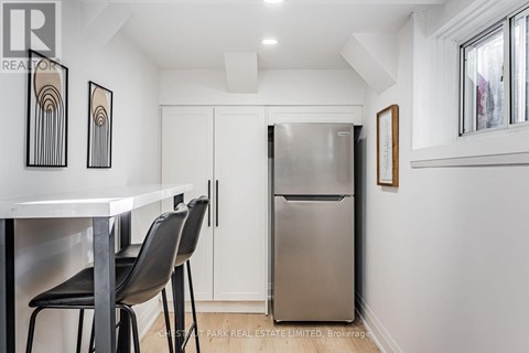 A kitchen with a white table and black chairs.