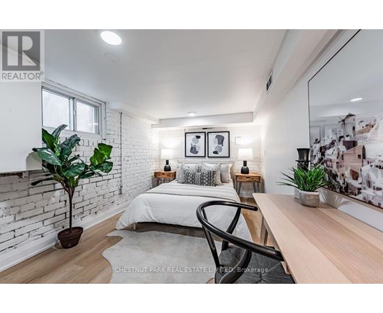 A bedroom with a white bed, a plant, and a mirror on the wall.