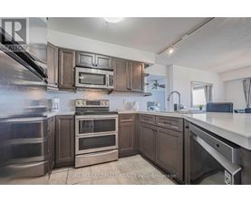 A kitchen with dark wood cabinets and stainless steel appliances.