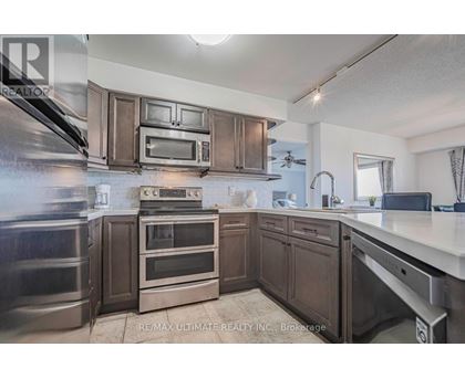 A kitchen with dark wood cabinets and stainless steel appliances.