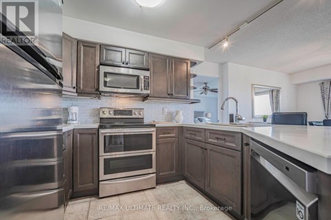 A kitchen with dark wood cabinets and stainless steel appliances.
