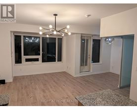A well-lit room with a chandelier and a rug on the floor.