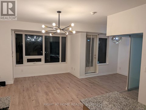A well-lit room with a chandelier and a rug on the floor.