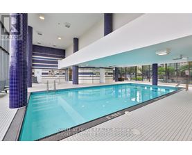 A large indoor swimming pool with a tiled wall and floor.