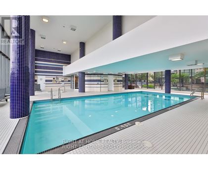 A large indoor swimming pool with a tiled wall and floor.