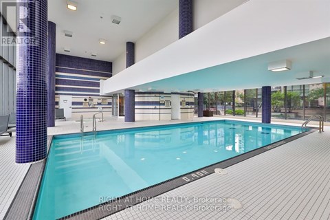 A large indoor swimming pool with a tiled wall and floor.