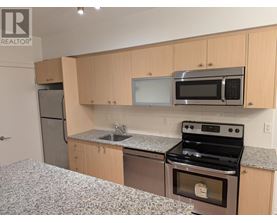 A kitchen with a stove, microwave, and refrigerator.