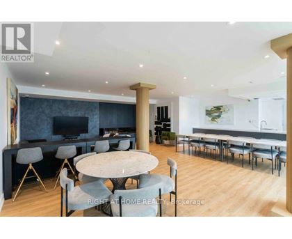 A modern dining room with a round table and chairs.