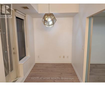 A room with a window and a wooden floor.