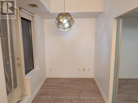 A room with a window and a wooden floor.