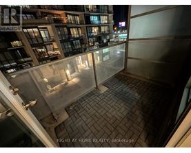 A balcony of a building with a glass railing and tiled floor.