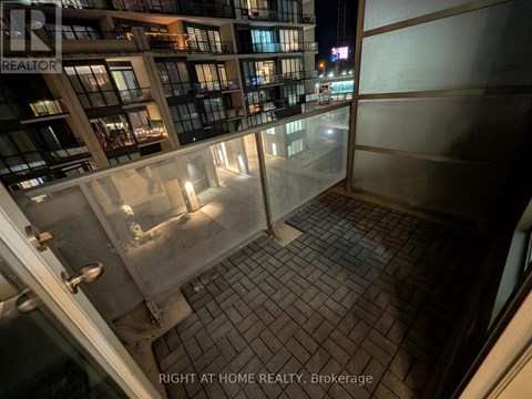 A balcony of a building with a glass railing and tiled floor.