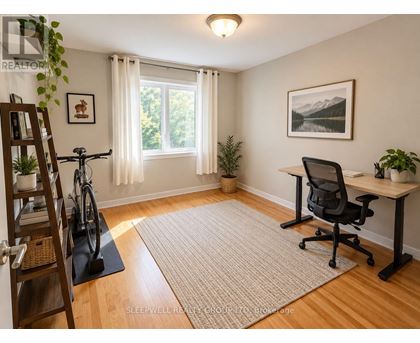 A room with a desk, chair, and bicycle.
