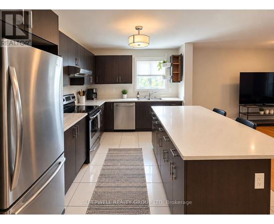 A modern kitchen with a stainless steel refrigerator and dark wood cabinets.