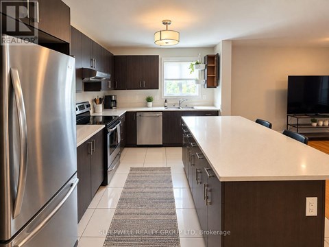 A modern kitchen with a stainless steel refrigerator and dark wood cabinets.