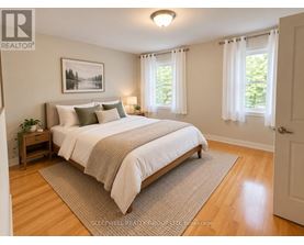 A bedroom with a large bed and a painting on the wall.