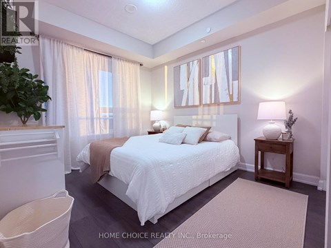 A bedroom with a large bed and a plant on the side table.