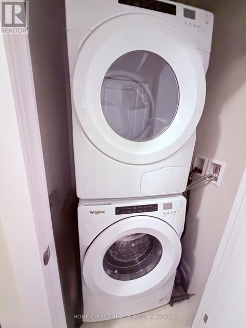 A white Whirlpool washing machine and dryer in a small laundry room.