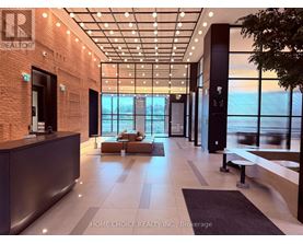A modern office lobby with a reception desk and a view of the city.