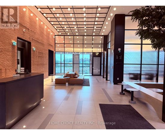 A modern office lobby with a reception desk and a view of the city.