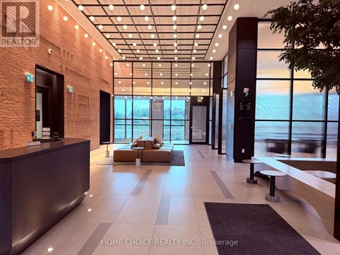A modern office lobby with a reception desk and a view of the city.