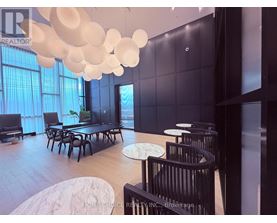 A modern dining room with a long table and chairs.