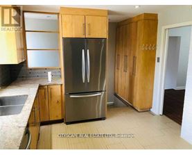 A kitchen with wooden cabinets and a stainless steel refrigerator.