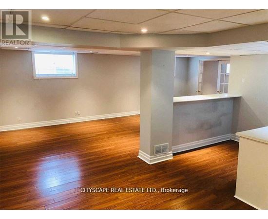 A room with wooden floors and a large window.