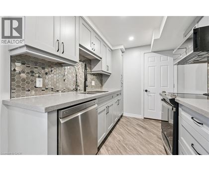 A kitchen with white cabinets and a tile backsplash.