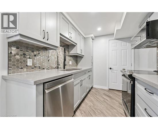 A kitchen with white cabinets and a tile backsplash.