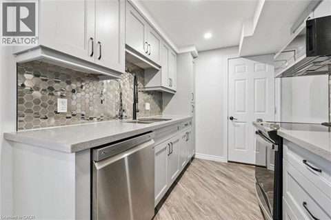 A kitchen with white cabinets and a tile backsplash.