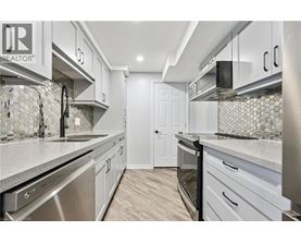 A kitchen with white cabinets and a tile backsplash.