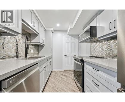 A kitchen with white cabinets and a tile backsplash.