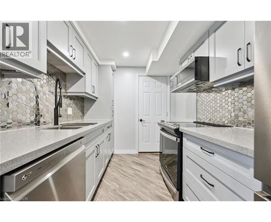 A kitchen with white cabinets and a tile backsplash.