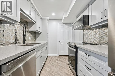 A kitchen with white cabinets and a tile backsplash.