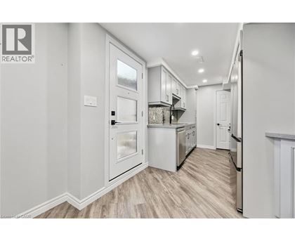 A kitchen with white cabinets and a refrigerator.