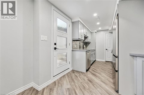 A kitchen with white cabinets and a refrigerator.