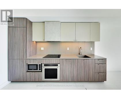 A modern kitchen with a microwave and oven built into the cabinetry.