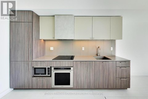 A modern kitchen with a microwave and oven built into the cabinetry.