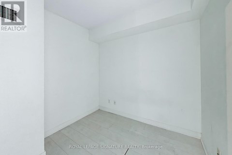 A white room with a wooden floor and a white wall.