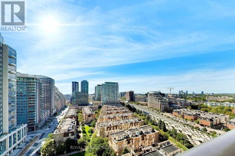 A cityscape with a mix of modern and older buildings under a clear sky.