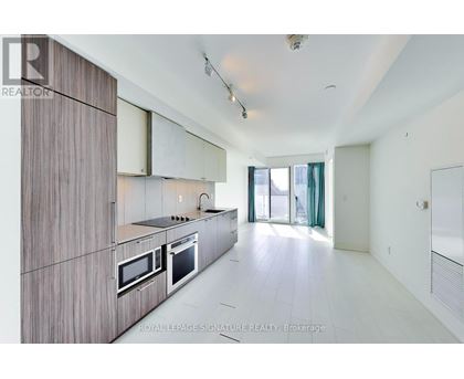 A modern kitchen with wooden cabinets and stainless steel appliances.