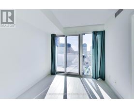 A white room with a sliding glass door leading to a balcony.