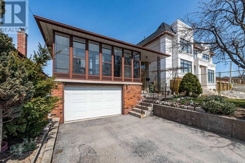 A house with a white garage door and a brick chimney.